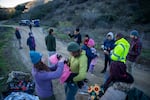 Members of humanitarian Borderlands Relief Collective help to treat a group of migrants who walked for roughly seven hours through rugged terrain on Otay Mountain in California on Jan. 13, 2024.
