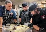 Chef Rob Kinneen, left, instructs culinary students Trysten Archuleta, center, and Nick Dickson who are helping prepare bison cheek for a First Foods dinner on Nov. 22, 2025.