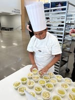 Fernando Gutierrez arranges samples of his pozole.
