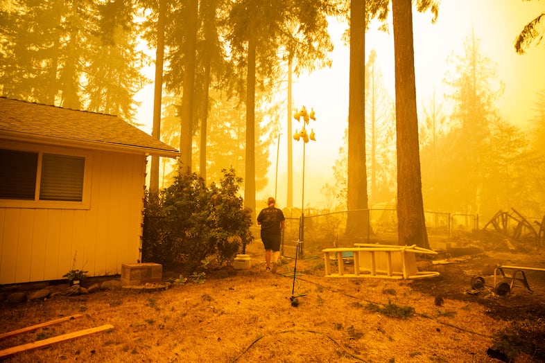 Chelsea DeVos scrambles to salvage possessions from her home as the Santiam Fire approaches near Gates, Ore., Sept. 9, 2020. Fires around Oregon could become the deadliest, costliest in state history.