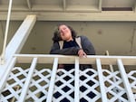 Sam, a student in OPB's Class Of 2025 project, looks down from the balcony outside his family's apartment in Springfield, Ore., June 21, 2022. 