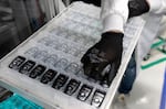 A worker assembles electronic car keys at a manufacturing plant in Tlajomulco de Zuniga, Jalisco State, Mexico, on February 20. The small, handheld remote controls are assembled in Mexico, but they cross borders in North America several times before being finished, like countless other auto parts.