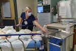 The health care sector saw the largest job gains in January. In this file photo, a staff member tries to move a cart and patient out of the way to make space for a new patient to be brought in at the Salem Health emergency department in Salem, Oregon, Jan. 27, 2022.