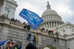 Supporters of President Donald Trump climb the West wall of the the U.S. Capitol, Jan. 6, 2021, in Washington.