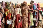 People who fled the Zamzam camp for the internally displaced after it fell under RSF control, queue for food rations in a makeshift encampment in an open field near the town of Tawila in war-torn Sudan's western Darfur region on April 13, 2025.