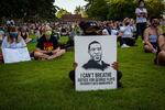 An attendee holds up a protest sign for the vigil of George Floyd at Peninsula Park in Portland, Ore., Friday, May 29, 2020. The sign features an illustration of George Floyd made by Minneapolis-based artist Andres Guzman.