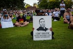 An attendee holds up a protest sign for the vigil of George Floyd at Peninsula Park in Portland, Ore., Friday, May 29, 2020. The sign features an illustration of George Floyd made by Minneapolis-based artist Andres Guzman.