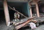 A man sits amidst debris of a house deluged in sludge following flash floods at Devighat in Nepal's Nuwakot district.