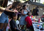 Raytonia Mcintyre braids hair at the Juneteenth celebration at Vance Park in Gresham, Ore., on June 19, 2026.