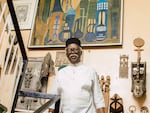 Artist Bruce Onobrakpeya stands before a wall of his artworks at his home studio in Lagos. The studio fills two floors of his three-story residence.