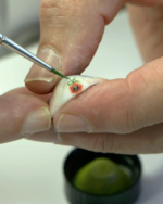 Harwin painting a tiny, personal image on the top of the prosthetic.