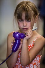 Shelby draws on her animal balloon, made for her by a local clown, at Earl Boyles Elementary School.