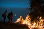 FILE - In this Sept. 11, 2020, file photo, firefighters light a controlled burn along Nacimiento-Fergusson Road to help contain the Dolan Fire near Big Sur, Calif. Crews across the West are lighting controlled burns and taking other steps to prepare for the 2021 fire season that follows the worst one on record. Prescribed burning gets rid of vegetation that can send flames into the forest canopy, where fire can spread easily, and makes the forest more fire resilient.