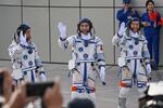 From left, astronauts for China's Shenzhou-18 space mission Li Guangsu, Ye Guangfu and Li Cong wave during a departure ceremony before boarding a bus to take them to the Shenzhou-18 spacecraft at the Jiuquan Satellite Launch Center in the Gobi desert in northwest China on Thursday.