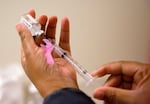 FILE - In this Feb. 7, 2018, file photo, a nurse prepares a flu shot at the Salvation Army in Atlanta.