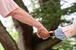 On Saturday April 22, 2023 at Arlington House families hold hands during a healing circle at the Finding Our Voice program.