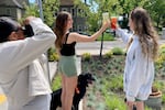 Members of University of Oregon acrobatic and tumbling team Emily Rezner and Bella Swarthout have their photo taken by grad student Myelle Norton at Dutch Bros on May 8, 2025, in Eugene, Ore. The athletes have contracted with Dutch Bros to created social media posts with beverages from the company.