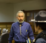 Democratic Oregon state Sen. Floyd Prozanski greets an Oregon State Trooper at the conclusion of the Oregon Senate Judiciary Committee's hearing on Senate Bill 978 the Oregon Capitol in Salem, Ore., Tuesday, April 2, 2019. He makes his way through a crowded room of opponents and supporters of the proposed gun control legislation.