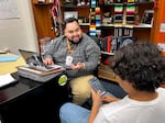 Alberto Plata-Hurtado helps a Benson Polytechnic High School Escalera senior with his FAFSA on April 17, 2024. The Education Department rejected the student’s application due to a spelling error.