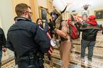 In this Jan. 6, 2021, file photo supporters of President Donald Trump are confronted by U.S. Capitol Police officers outside the Senate Chamber inside the Capitol in Washington. An Arizona man seen in photos and video of the mob wearing a fur hat with horns was also charged Saturday in Wednesday's chaos. Jacob Anthony Chansley, who also goes by the name Jake Angeli, was taken into custody Saturday, Jan. 9.