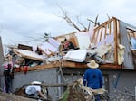 Omaha police officers search a home for a family after a tornado leveled dozens of homes near Omaha, Neb., on Friday, April 26, 2024.