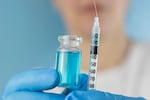 ghk cu peptide vial syringe medical hands holding liquid blue solution medication vaccine close up view looking away concept of biochemistry, healthcare, pharmacology.