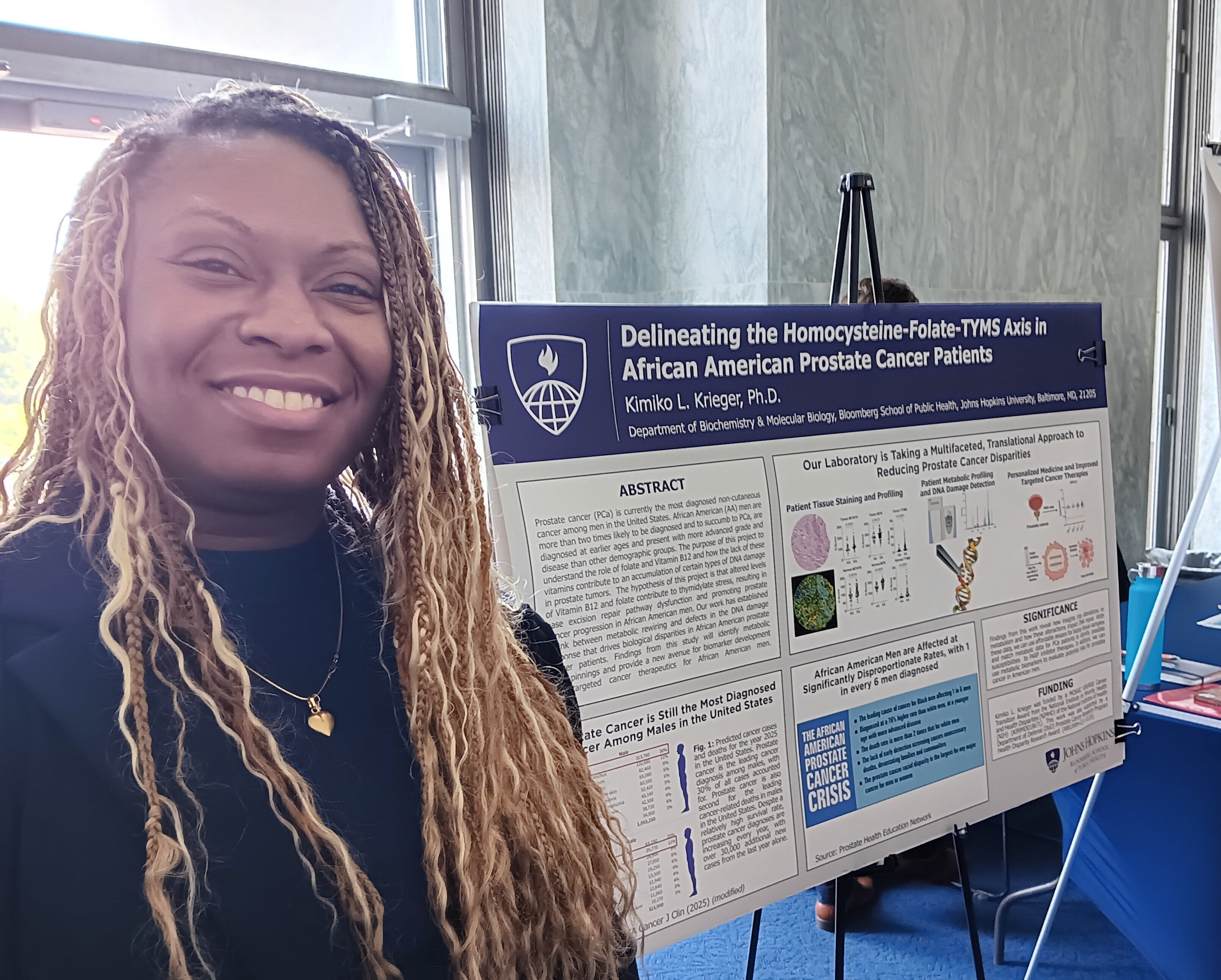Kimiko Krieger, an assistant professor of biochemistry and molecular biology at the Bloomberg School for Public Health at Johns Hopkins University, stands before a poster describing her research that lost federal funding.