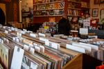 Records in the foreground with a customer buying records at the counter.