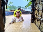 A Rohingya woman stands in chest-deep water during a 2021 flood. The refugee camp in Bangladesh is prone to natural disasters including floods, fires and landslides.