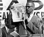 Malcolm X holds up a paper for the crowd to see during a Black Muslim rally in New York City on Aug. 6, 1963.