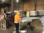 A worker takes apart a mattress at a St. Vincent de Paul recycling facility in Eugene.