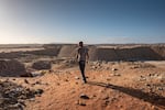 An illegal diamond miner looks out from the top of a De Beers mine that has since been taken over by zama-zamas.