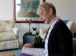 Carolyn Arntson at her Lake Oswego home, looking at records she's collected about veterans in Oregon on May 9, 2024. She spent the previous ten years searching for veterans whose remains never received a proper burial.