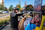 Fred looks through the costume rack, nicknamed "Operation Inflation", outside the U.S. Immigration and Customs Enforcement facility in Portland, Ore., on Wednesday, Oct. 15, 2025.