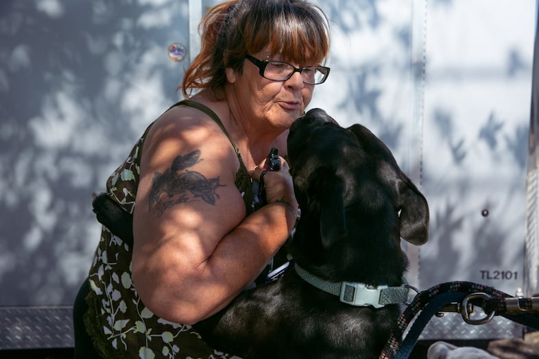 Angela Constantin greets a friend's dog in front of Community Life Church in Monmouth. Constantin, 59, lives at the new shelter in town while she applies for housing and a new job.
