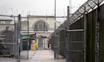 FILE - In this Jan. 28, 2016, file photo, a man does maintenance work between razor wire-topped fences at the Monroe Correctional Complex in Monroe, Wash.