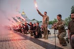 People light up flares during the funeral ceremony of fallen Ukrainian serviceman Yaroslav Ivanov in Kyiv, Ukraine, on June 8.