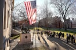 FILE - People take photos near a John Harvard statue, left, on the Harvard University campus, Jan. 2, 2024, in Cambridge, Mass.