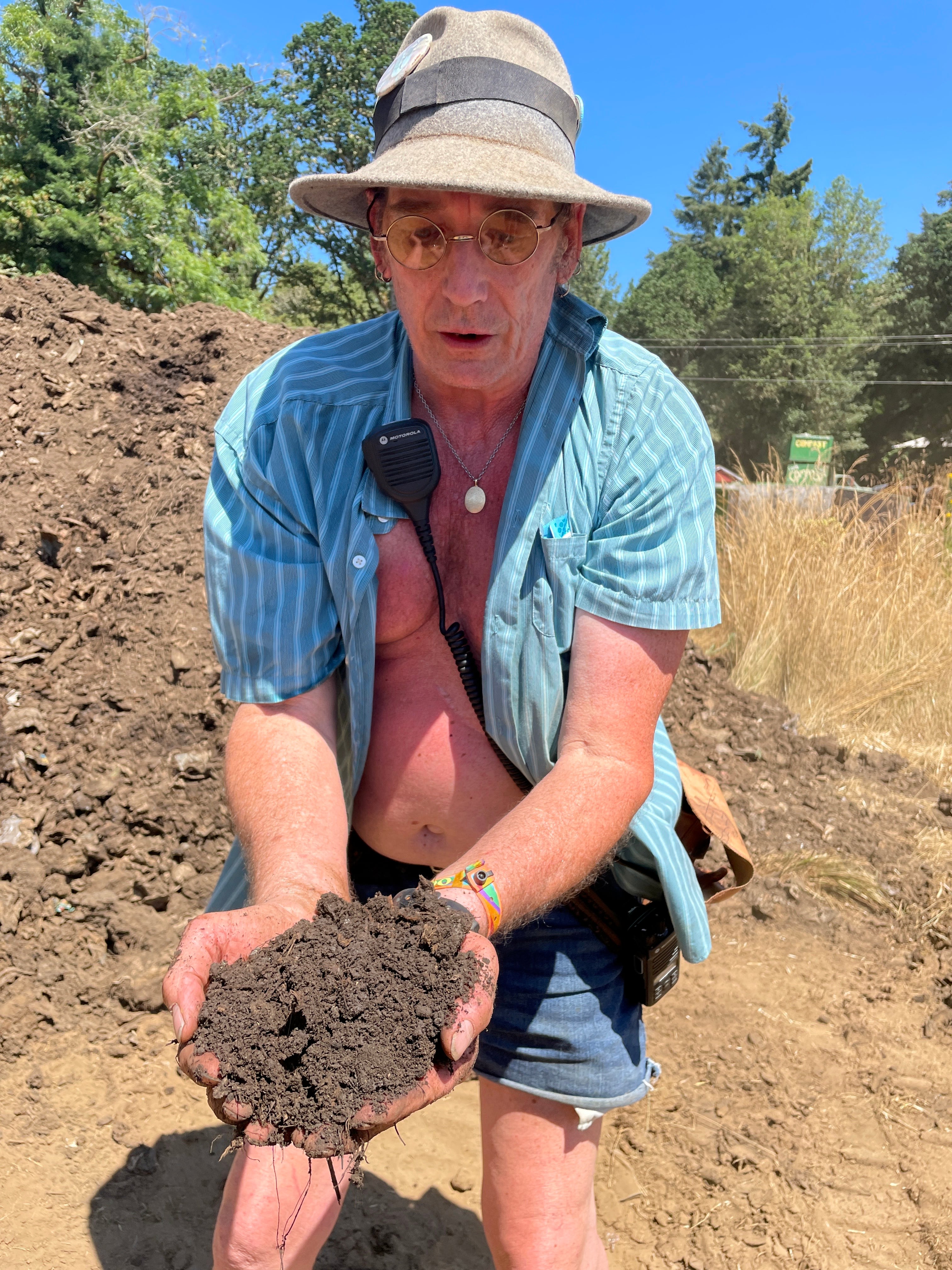 Composting crew coordinator Thom Barr holds a handful of compost generated on the Oregon Country Fair site in July 2024. Compost has become a big part of the fair’s recycling program.
