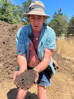 Composting crew coordinator Thom Barr holds a handful of compost generated on the Oregon Country Fair site in July 2024. Compost has become a big part of the fair’s recycling program.
