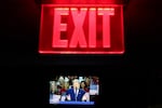 Seen on a screen below an exit sign, President Trump speaks on the first day of the 2026 Republican convention on Sept. 9 in Dallas.