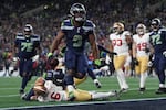 Seattle Seahawks running back Kenneth Walker III (9) scores a touchdown during the second half of an NFL football divisional playoff game against the San Francisco 49ers, Saturday, Jan. 17, 2026, in Seattle.