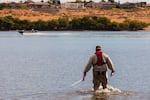 Jason Pappani stretches a tape measure out into the Columbia River at Leslie Groves Park to grid the shoreline and shallow river for scientific algae measurements.