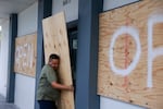 Salvador Gonzalez places plywood over the windows of a business before Hurricane Milton's arrival on October 9, 2024 in Fort Myers, Florida. 