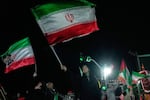 Pro-government demonstrators wave Iranian flags during a gathering in Tehran, Iran, Monday, April 27, 2026.