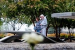 A man and woman stand near a memorial bench to read its nameplate at the National 9/11 Pentagon Memorial in Arlington, Virginia, on September 10, 2025.