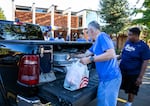 George Fox University President Robin Baker helps unload Rylan Nelson's belongings as Nelson moves into the dorms.