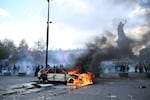 A car burns at Place de La Republique during a protest against rising living costs in Paris on Saturday.