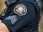 A Portland Police Bureau officer with his hand lifted towards his face.