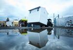 Crews from Pallet move new pods into a homeless camp in Portland, Ore., Wednesday, Dec. 9, 2020. Portland this month assembled neat rows of the shelters, which resemble garden sheds, in three ad-hoc “villages”,  part of an unprecedented effort unfolding in cold-weather cities nationwide to keep people without permanent homes safe as temperatures drop and coronavirus cases surge.